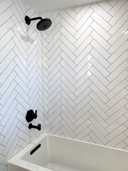 Subway-TIle-in-Herringbone-Pattern-with-Matte-Black-Fixtures