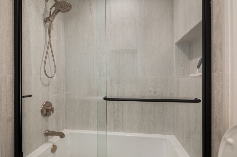 Guest-bathroom-with-textured-wall-tile-and-gold-fixtures
