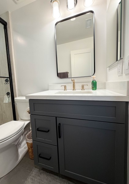 Dark-Gray-Guest-Bathroom-Vanity-with-Matte-Black-Hardware-and-Gold-Fixtures