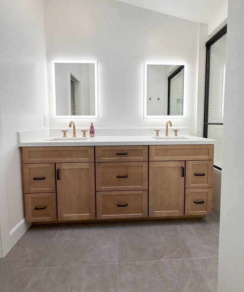 Light-Wood-Tone-Bathroom-Vanity-with-Matte-Black-Cabinetry-Pulls-and-Gold-Fixtures