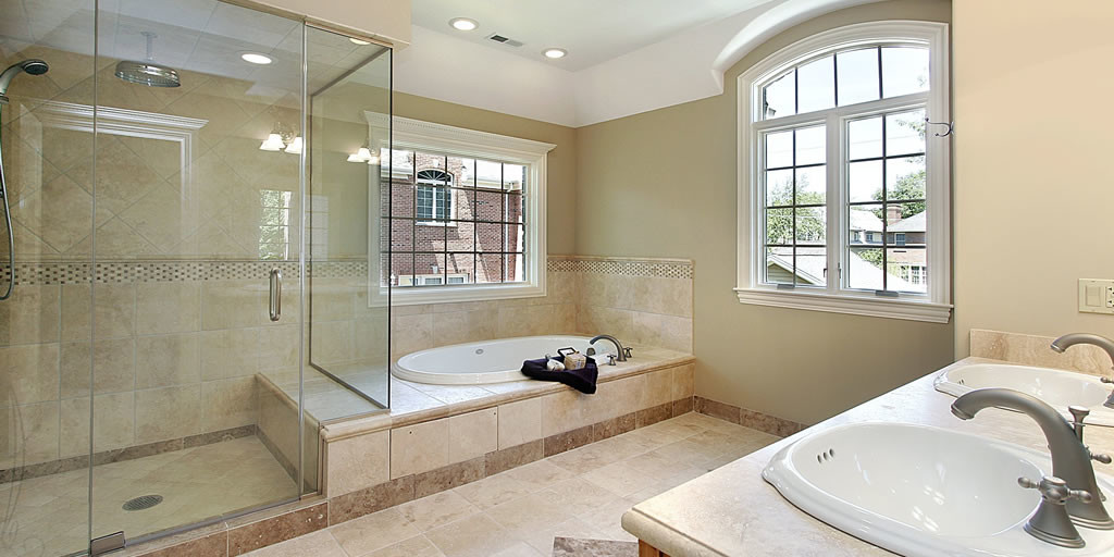 orange county shower remodeling uses framless glass to create a shower enclosure next to soaking tub