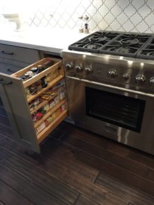 custom kitchen remodeling contractor converted wasted space into a pull out spice drawer