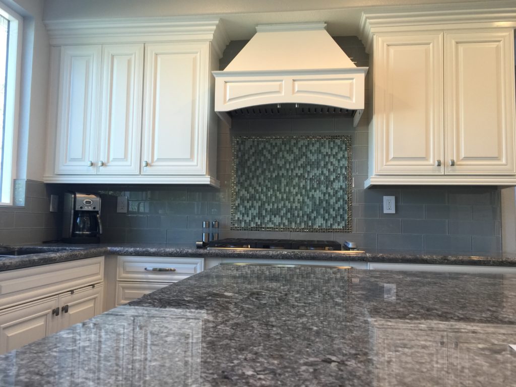kitchen cabinet contractor adds valance to hood to give a custom look to kitchen