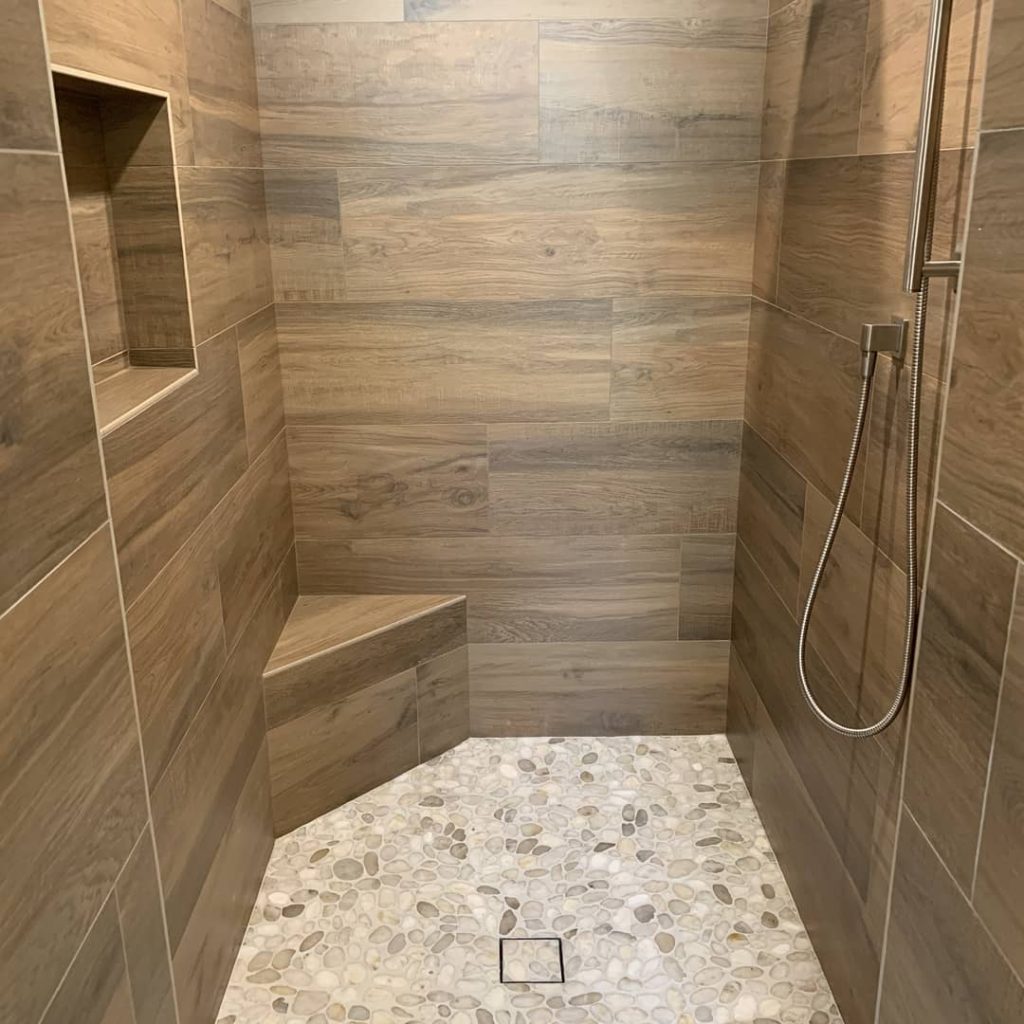 general contractors creates shower out of wood look tile for natural effect