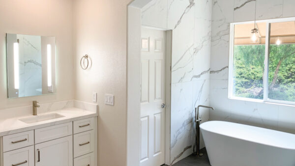 White vanity with marble look tub wainscoting