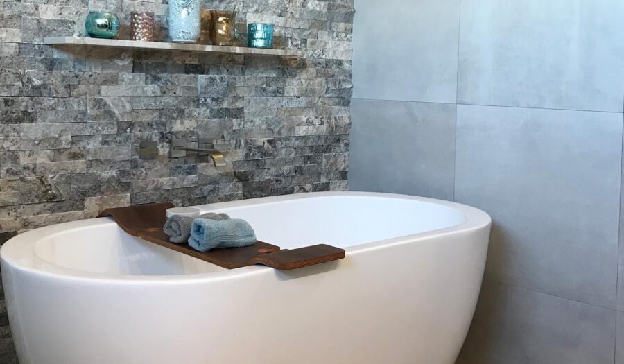 bathroom designers match stacked stone and soaking tub for spa feel