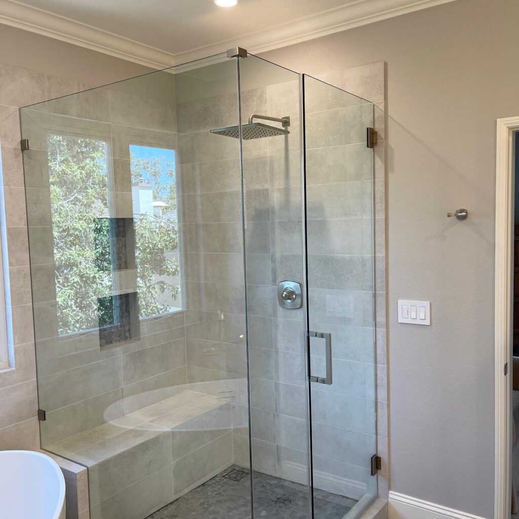 Orange County bathroom designers use frameless glass to create a 2-sided shower enclosure
