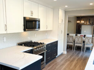 Black and white kitchen cabinetry with wood look flooring