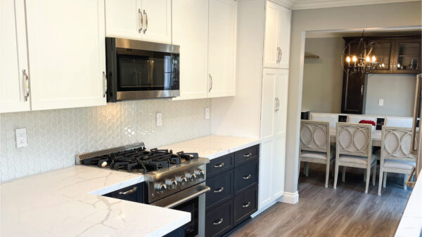 Black and white kitchen cabinetry with wood look flooring