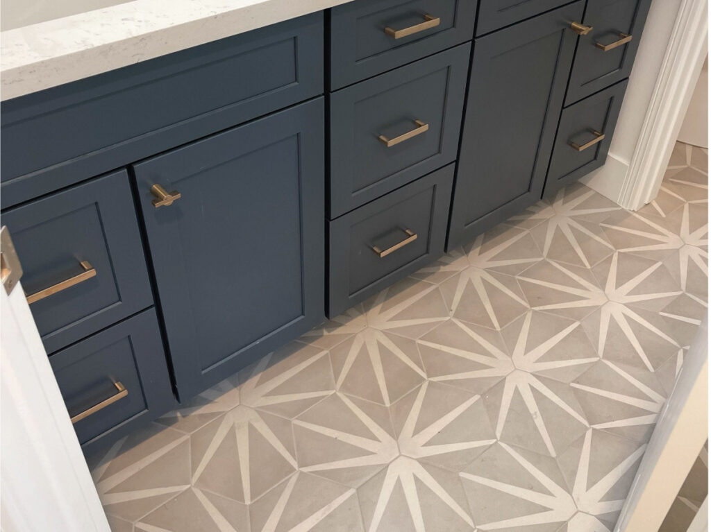 after bathroom remodel flooring contractor shows grey and white pattern tile flooring and blue vanity