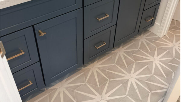 after bathroom remodel flooring contractor shows grey and white pattern tile flooring and blue vanity