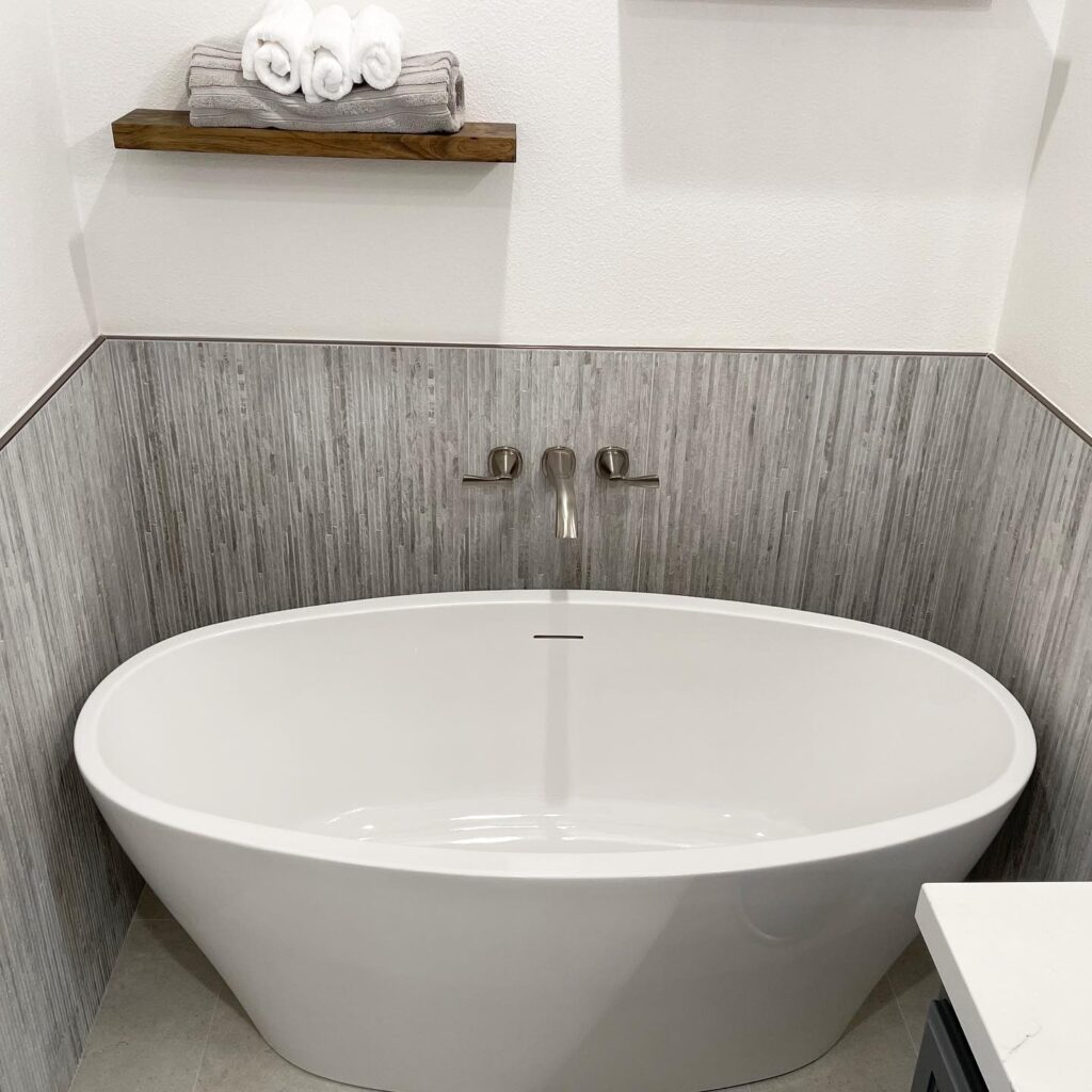 linen look tile on wall surrounds white soaking tub