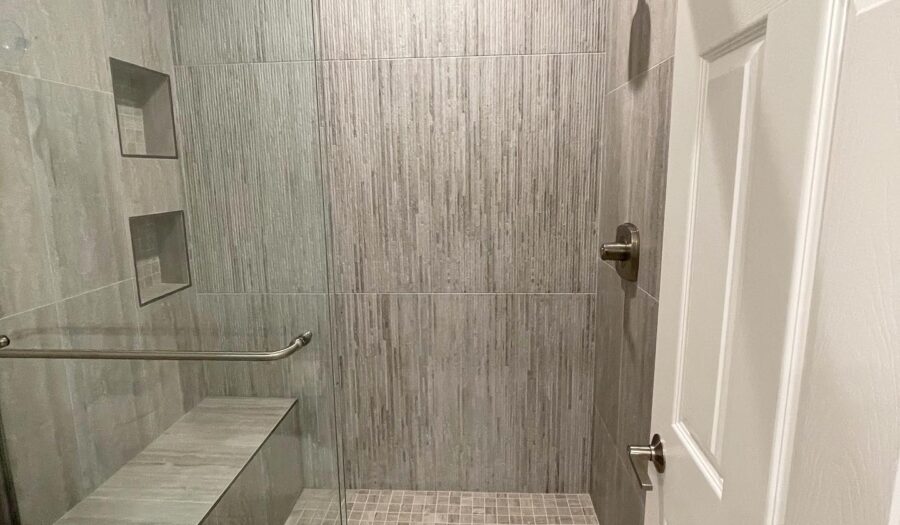shower remodel features earth tone lnen tiles on walls and bench