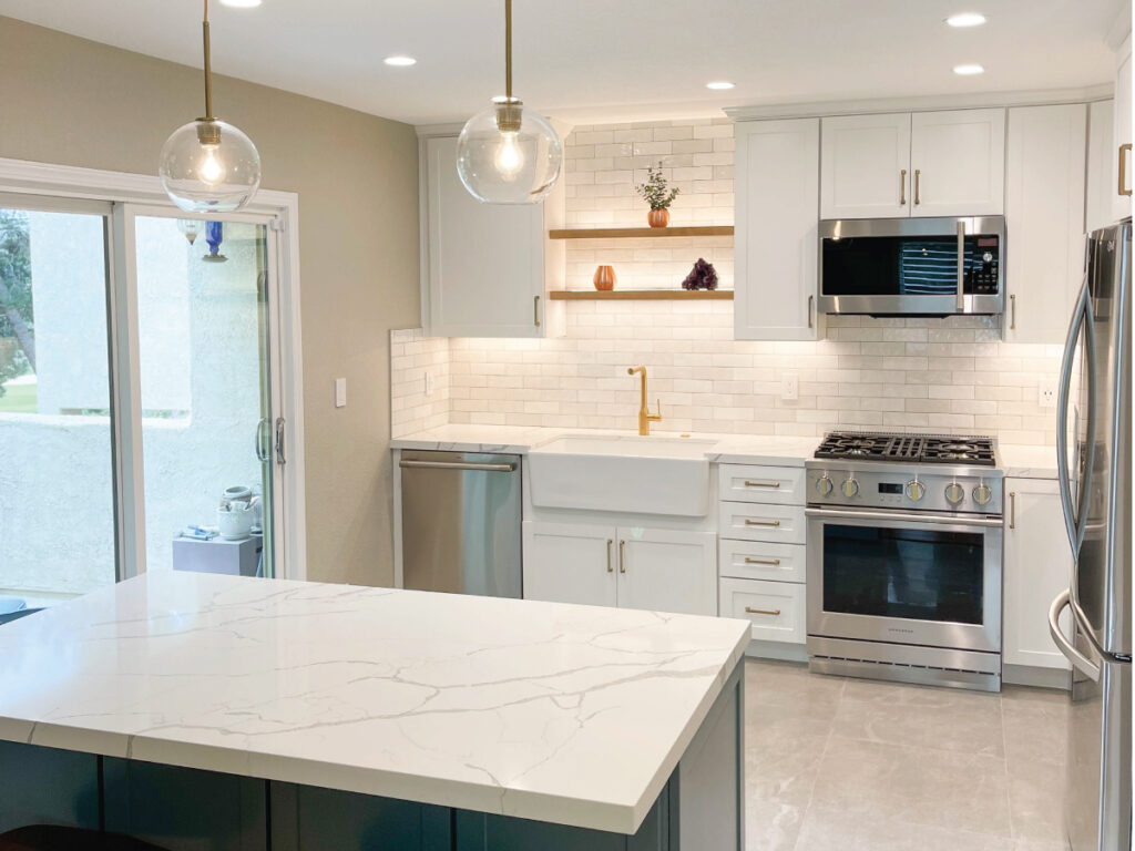 Teal and white custom cabinets in kitchen with white countertops and backsplash