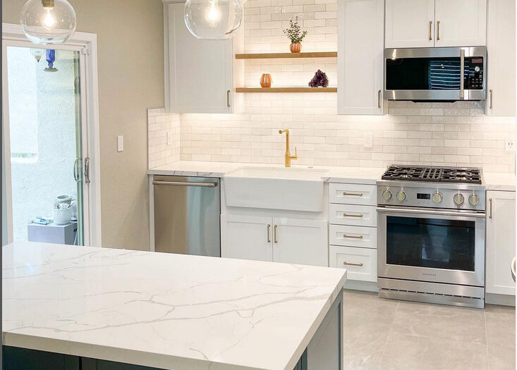 kitchen renovation after picture of undercabinet lighting, clear globe pendant lights, and recessed lights in the ceiling