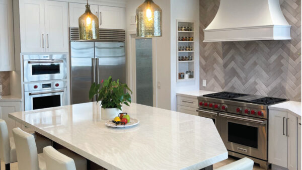 Grey herringbone backsplash tile with white cabinetry and Cambria countertops