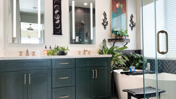 Green vanity with black subway tile