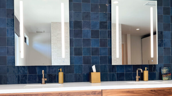 Navy backsplash tile with walnut cabinets and white countertops