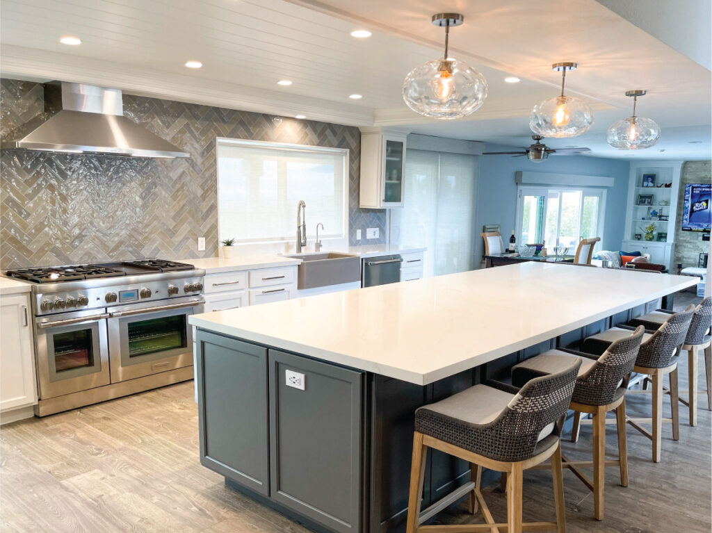 Grey and white kitchen cabinetry with large island and stainless appliances