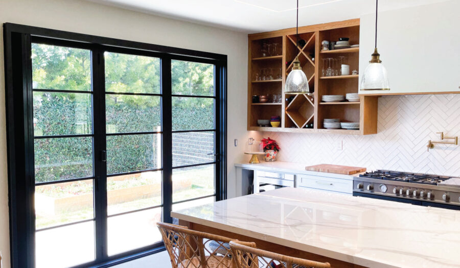 After kitchen remodeler adds open shelves storing white cups and plates