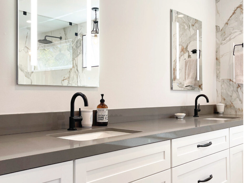 Grey quartz countertops with white cabinetry and black accessories