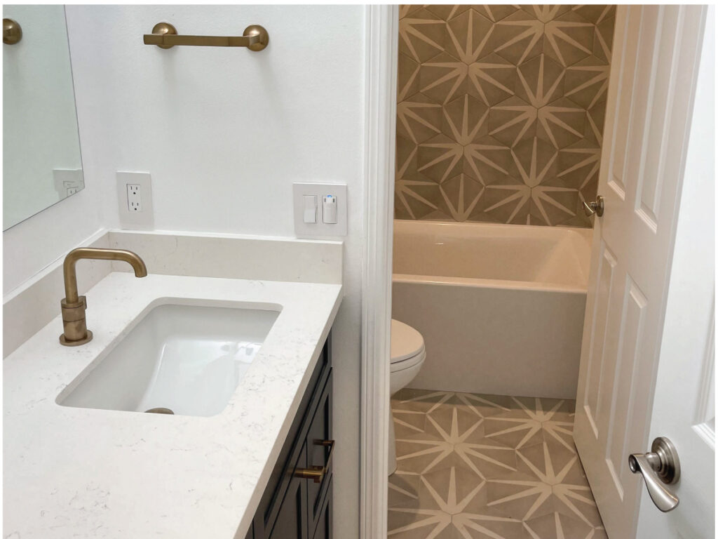 flooring contractor after picture: Taupe and white patterned hex tile in bathroom with navy vanity