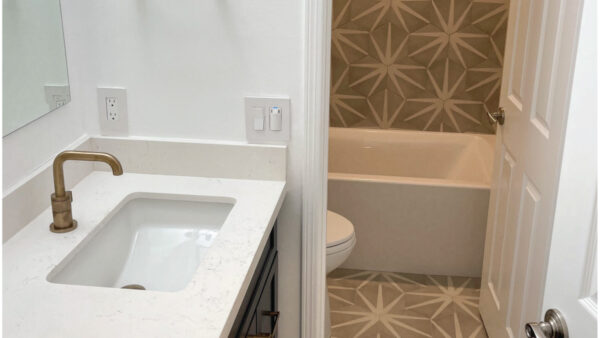 flooring contractor after bathroom remodeling: Taupe and white patterned hex tile in bathroom with navy vanity