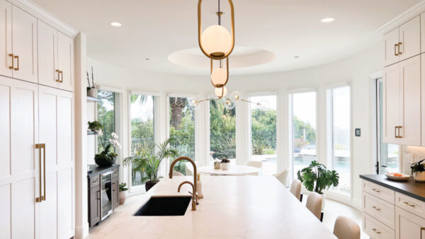 White kitchen cabinetry with gold accessories and light countertops