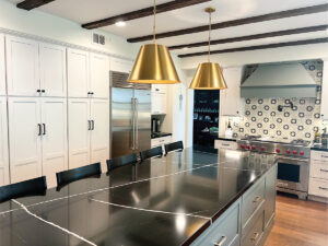 Green & white kitchen cabinetry with black quartz countertops