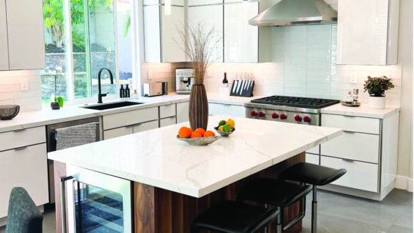 Slab front cabinets with white countertops for a modern kitchen