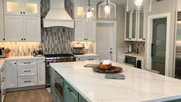 kitchen remodeling after photo stainless sttel stove and hood with gre, black & white backsplash