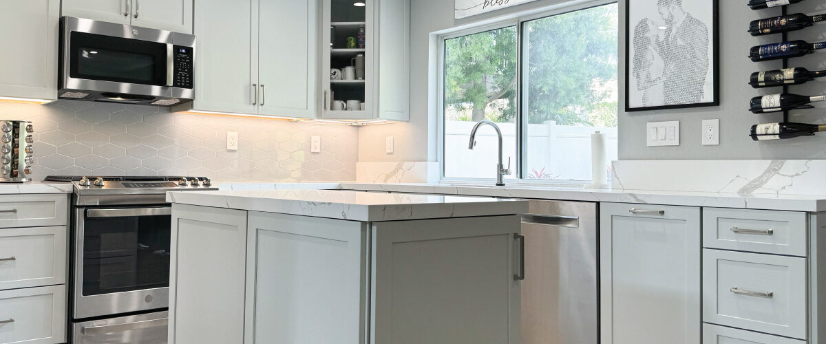 Kitchen with light grey cabinets, white quartz countertops, and light grey tile floors