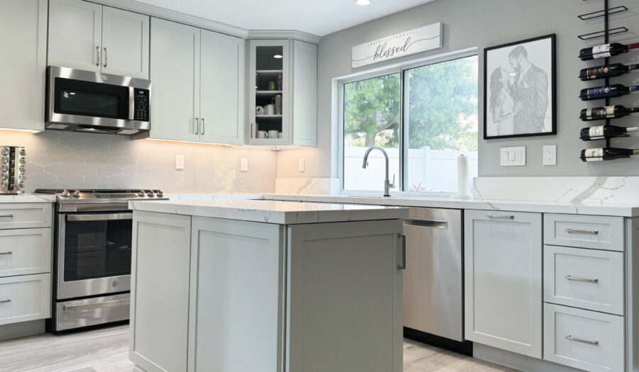 Kitchen remodeling after: light grey cabinets, white quartz countertops, and light grey tile floors