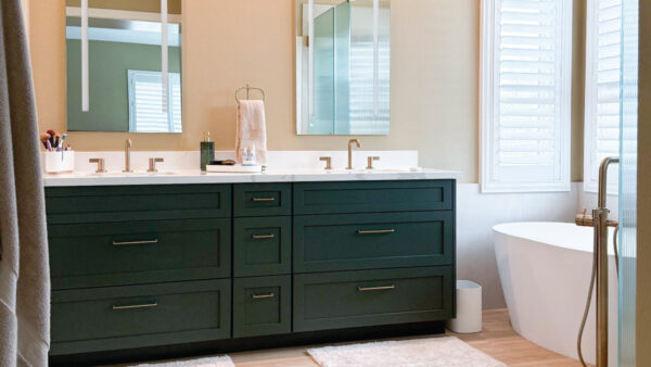 Modern organic bathroom design with light natural tones and a dark green vanity