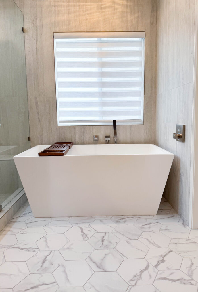 bathroom remodeling service after photo of freestanding white tub with teak tray and white marble floor